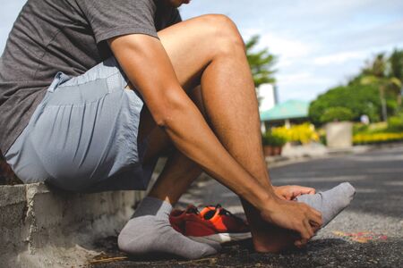 Close-up of man putting on sock before workout.の写真素材