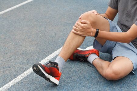 Close up of sport man suffering with pain on sports running knee injury after running.Injury from workout concept.の写真素材