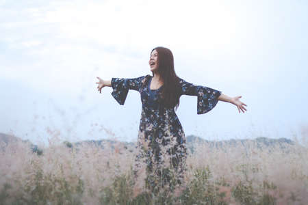 The woman in a blue dress on a wheat field. woman in meadow conceptの写真素材