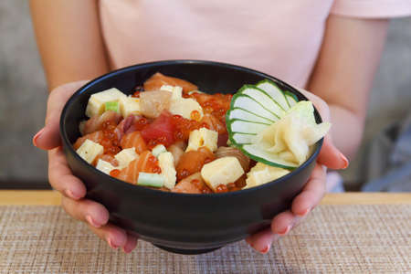 Japanese food. Hand's woman holding rice of Salmon, tuna ,Tekka Don