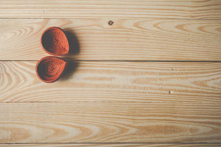 Happy Diwali - Clay Diya lamps lit during Dipavali, Hindu festival of lights celebration.oil lamp diya on wooden backgroundの写真素材