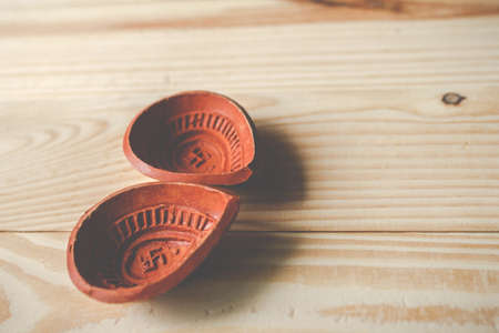 Happy Diwali - Clay Diya lamps lit during Dipavali, Hindu festival of lights celebration.oil lamp diya on wooden backgroundの写真素材