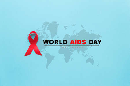 red AIDS awareness ribbon on the blue paper background. World aids day and healthcare and medicine conceptの写真素材
