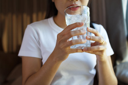 Close up of female drinking from a glass of water.