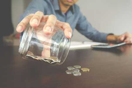 Money accounting concept. Businessman check coin in the bottle. Management and Finance