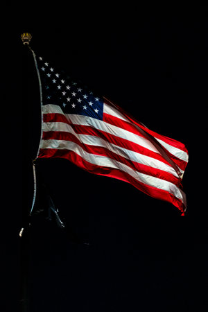 American Flag on a black background. Closeup of american USA flag, stars and stripes, united states of america. On a black background. At night. All seasons.の写真素材