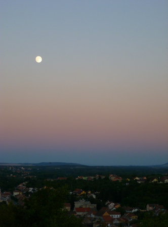 Photo of a full moon above a small townの写真素材
