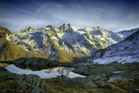 Great view of small lake in Gran Paradiso National Park,  Alps, Italy,  beautiful world. calm scenery with mountains covered by snow in background, majestic mountain landscape, wallpaperの写真素材
