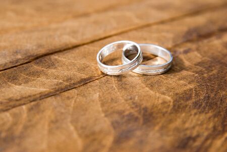 two silver wedding rings on wooden boardの写真素材