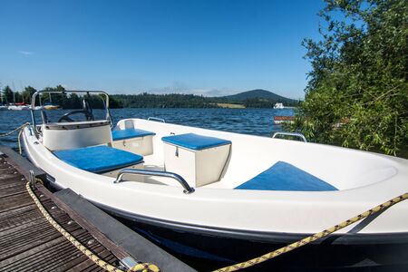 Small white blue boat with electric engine at marina Slezska Hartaの写真素材