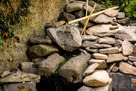 Bamboo water feature and little cobblestones tower in the gardenの写真素材