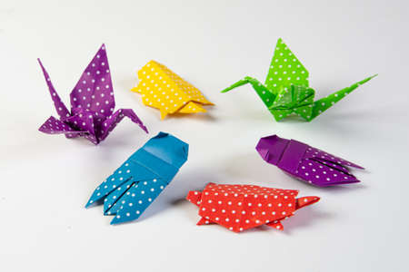 Group of origami animals made from blue, purple, yellow, green and red paper with dots isolated on white backgroundの写真素材