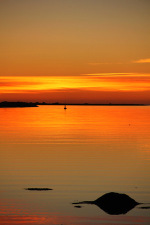 A stone reflecting in the sea during sunset near Reykjavik, Iceland.の写真素材