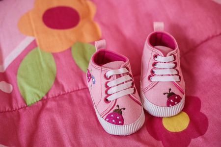 Pink shoes for little baby girl on a blanketの写真素材
