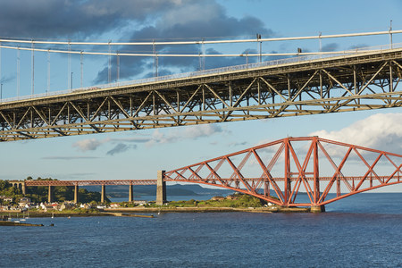 Older Forth Road bridge and the iconic Forth Rail Bridge in Edinburgh Scotlandの写真素材