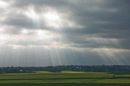 Beautiful countryside and sunrays passing through clouds on landscape with fields near Kiel - Schleswig-Holstein - Germany.の写真素材