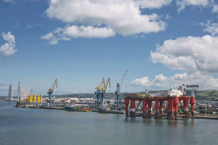 Belfast, Ireland - June 9, 2017: Large industrial cranes loading container ship in Belfast Port in...