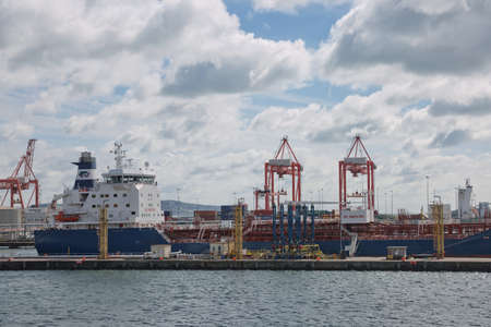 Dublin, Ireland - June 6, 2017: Large industrial cranes loading container ship in Dublin Port in...