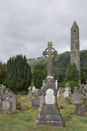 Glendalough, co. Wicklow, Ireland - August 10 2019 :Stone round tower and some ruins of a monastic settlement originally built in the 6th century in Glendalough valley, County Wicklow, Ireland.のeditorial素材