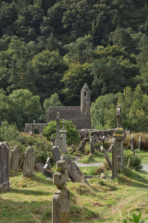 Glendalough, co. Wicklow, Ireland - August 10 2019 :Stone round tower and some ruins of a monastic settlement originally built in the 6th century in Glendalough valley, County Wicklow, Ireland.のeditorial素材