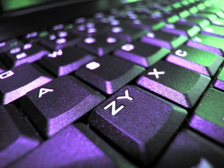 Macro of a computer's keyboard with blue and green lighting