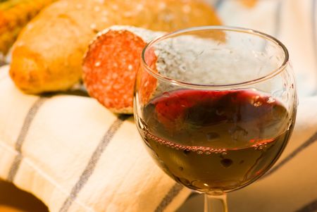 still life with red wine,sausage and bread rollの写真素材
