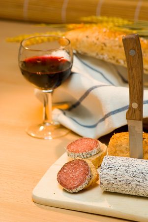 still life with red wine,sausage and bread rollの写真素材