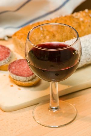 still life with red wine,sausage and bread rollの写真素材