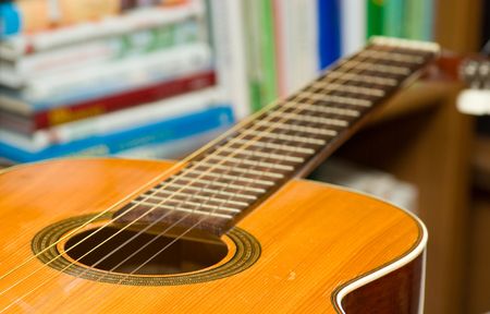 detail Spanish guitar in front of bookcaseの写真素材