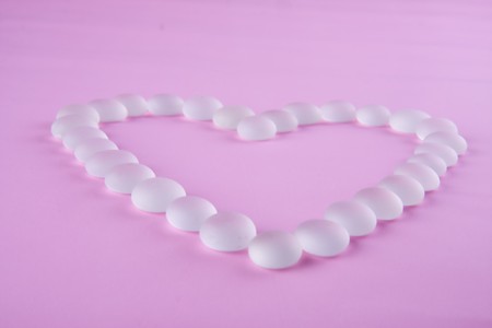 glass heart on pink backgroundの写真素材