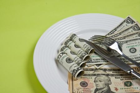 money on plate with fork and knifeの写真素材