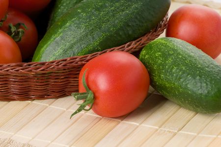 tomatoes and cucumbers in basketの写真素材