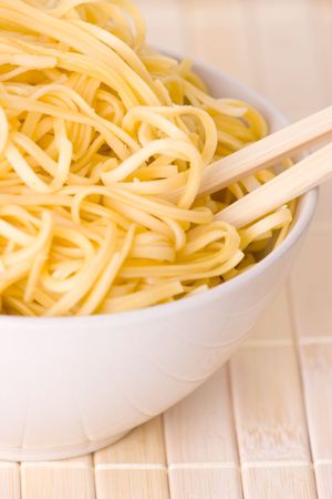 chopsticks,bowl and noodles on tableの写真素材
