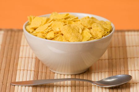 cornflakes in bowl on orange backgroundの写真素材