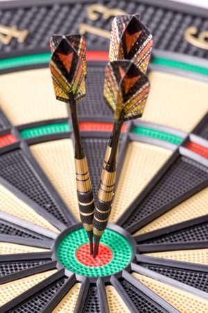 darts in dartboard on white backgroundの写真素材