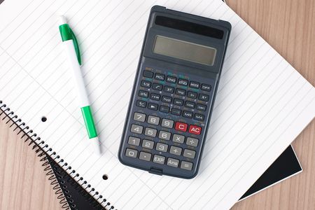 calculator,pen and notebook on tableの写真素材