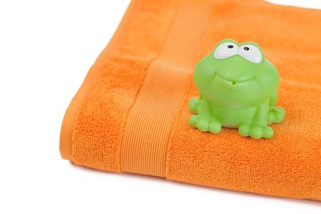 orange towel and toy frog on white backgroundの写真素材