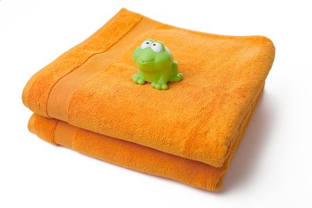 orange towels and toy frog on white backgroundの写真素材