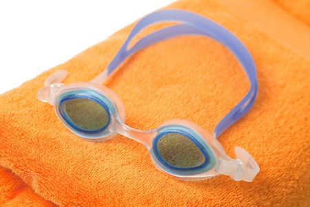 swimming glasses on orange towelの写真素材