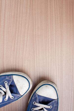 pair of blue sneakers on wooden floorの写真素材
