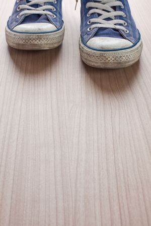 pair of blue sneakers on wooden floorの写真素材