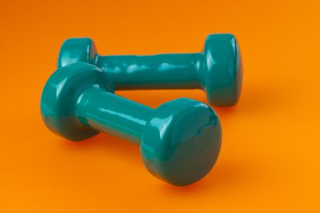 two green  dumbells on color backgroundの写真素材