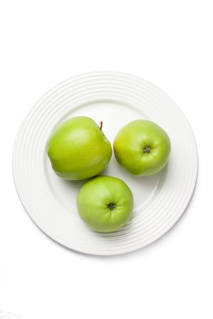 three green apples on white plateの写真素材