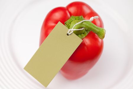 red pepper with label on white plateの写真素材