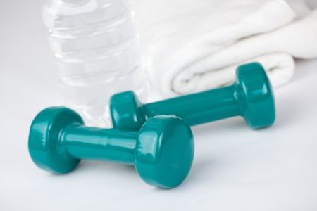 green dumbells with towel and water on white backgroundの写真素材