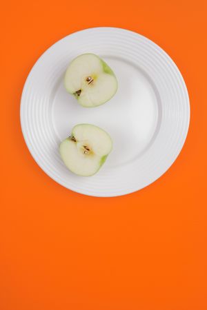 sliced green apple on white plateの写真素材