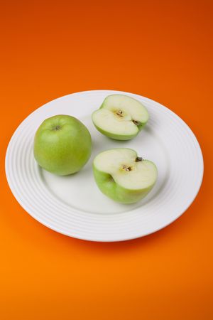 sliced green apple on white plateの写真素材