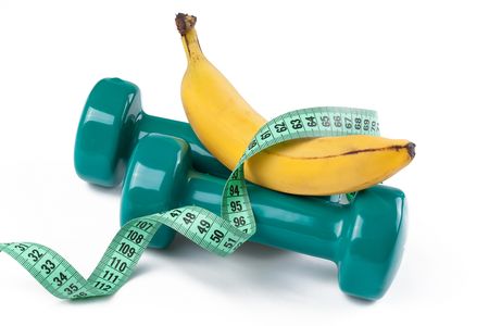 the green dumbell and yellow banana on white backgroundの写真素材