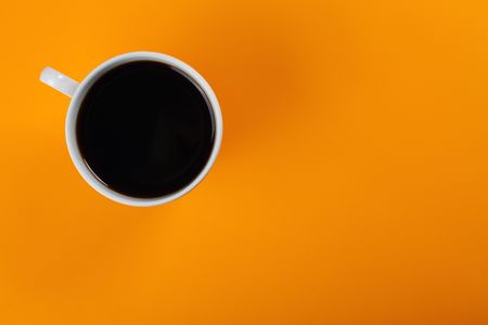 top view of coffee cup on color backgroundの写真素材