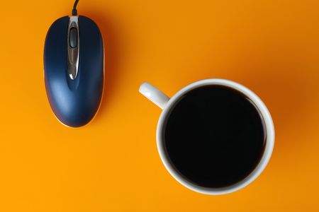 coffe cup and computer mouse on color backgroundの写真素材